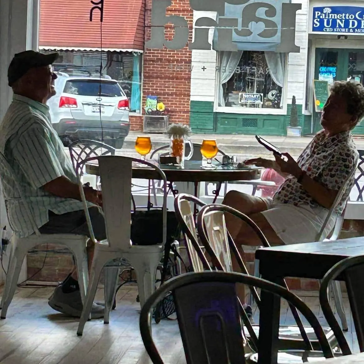 Two guests sharing drinks at a table inside Homeland
