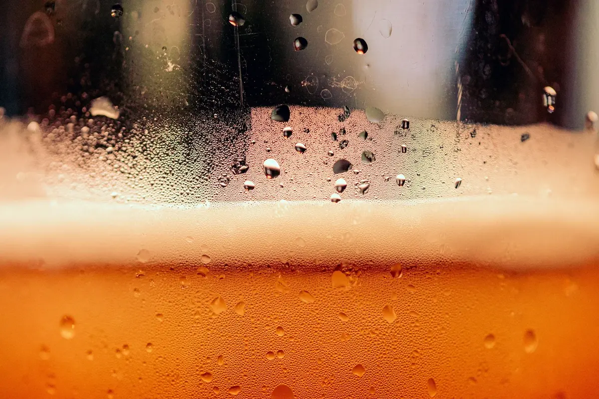 A cold glass of beer covered in condensation