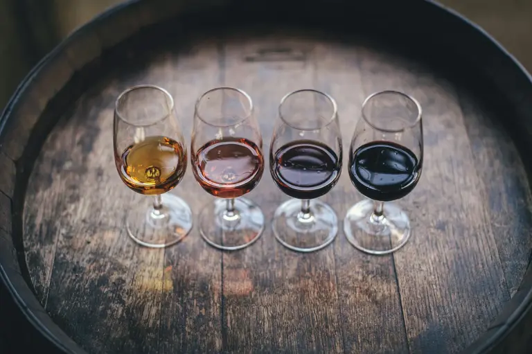 A flight of wines on a wooden barrel